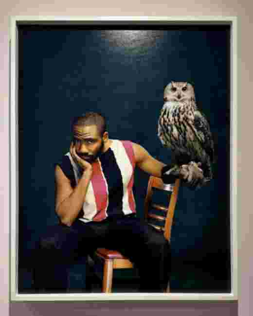 Portrait par Tyler Mitchell, homme assis avec une chouette sur fond bleu