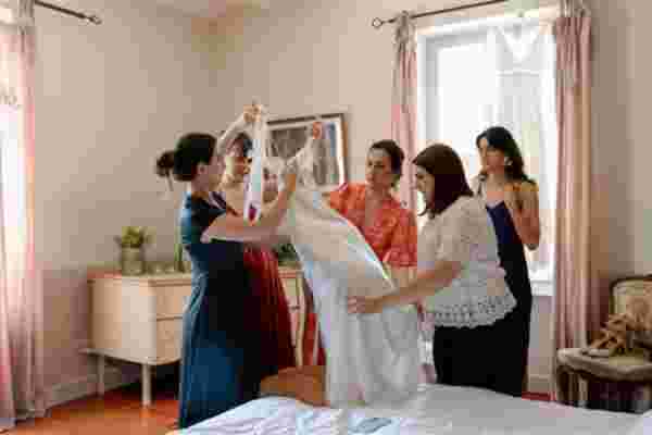 La mariée entourée de ses proches lors de l'habillage de la robe — Préparatifs mariage Château Le Bouïs, Occitanie