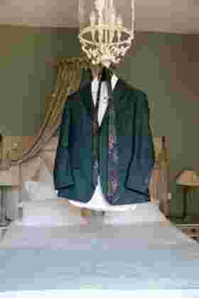 Costume et cravate du marié suspendus dans une chambre du Château Le Bouïs, Gruissan