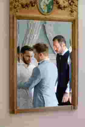 Marié aidé par ses témoins pour s'habiller, reflet dans un miroir doré — Mariage Gruissan, Occitanie
