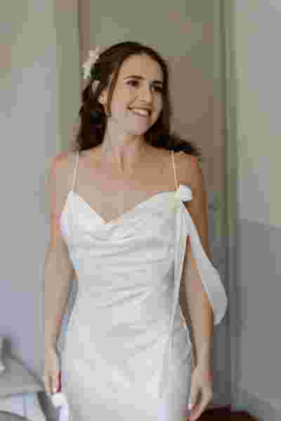 Portrait de la mariée souriante en robe blanche à bretelles — Mariage Château Le Bouïs, Occitanie