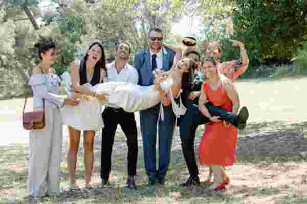 Groupe d'amis portant la mariée en riant dans le parc de Narbonne — Mariage Château Le Bouïs, Gruissan