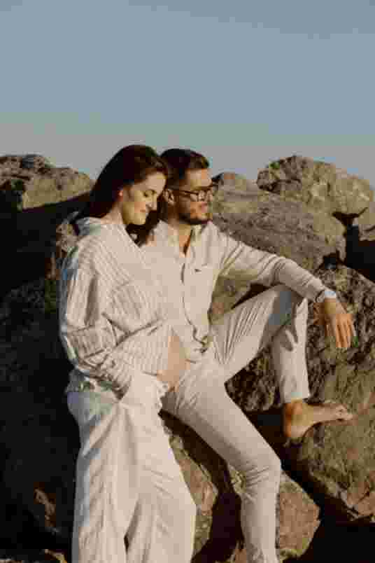 Couple assis sur les rochers - Séance maternité Frontignan Plage