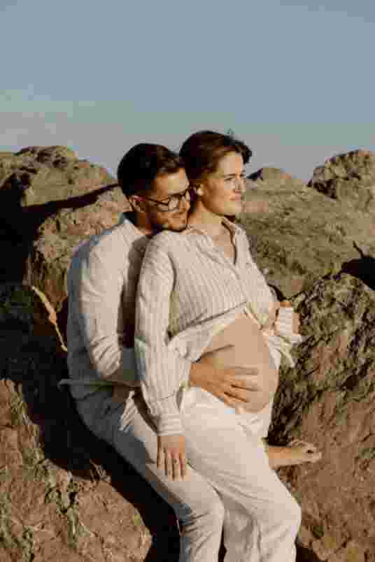 Couple assis sur les rochers - Séance maternité Frontignan Plage