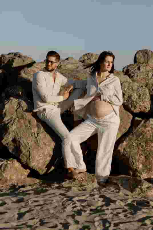 Couple assis sur les rochers - shooting maternité Frontignan Plage